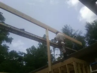 Carpenter setting a ridge beam over a new addition frame — Ice Dam Removal by Roofing Brothers in Burnet