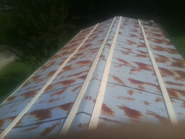 Rusted metal roof panels with new wood purlins before replacement — Storm Damage Roof Repair in Burnet by Roofing Brothers