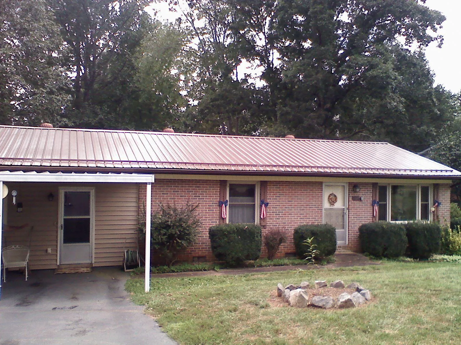 Bronze metal roof and carport on a brick ranch home — Roof Repair work by our crew in Burnet